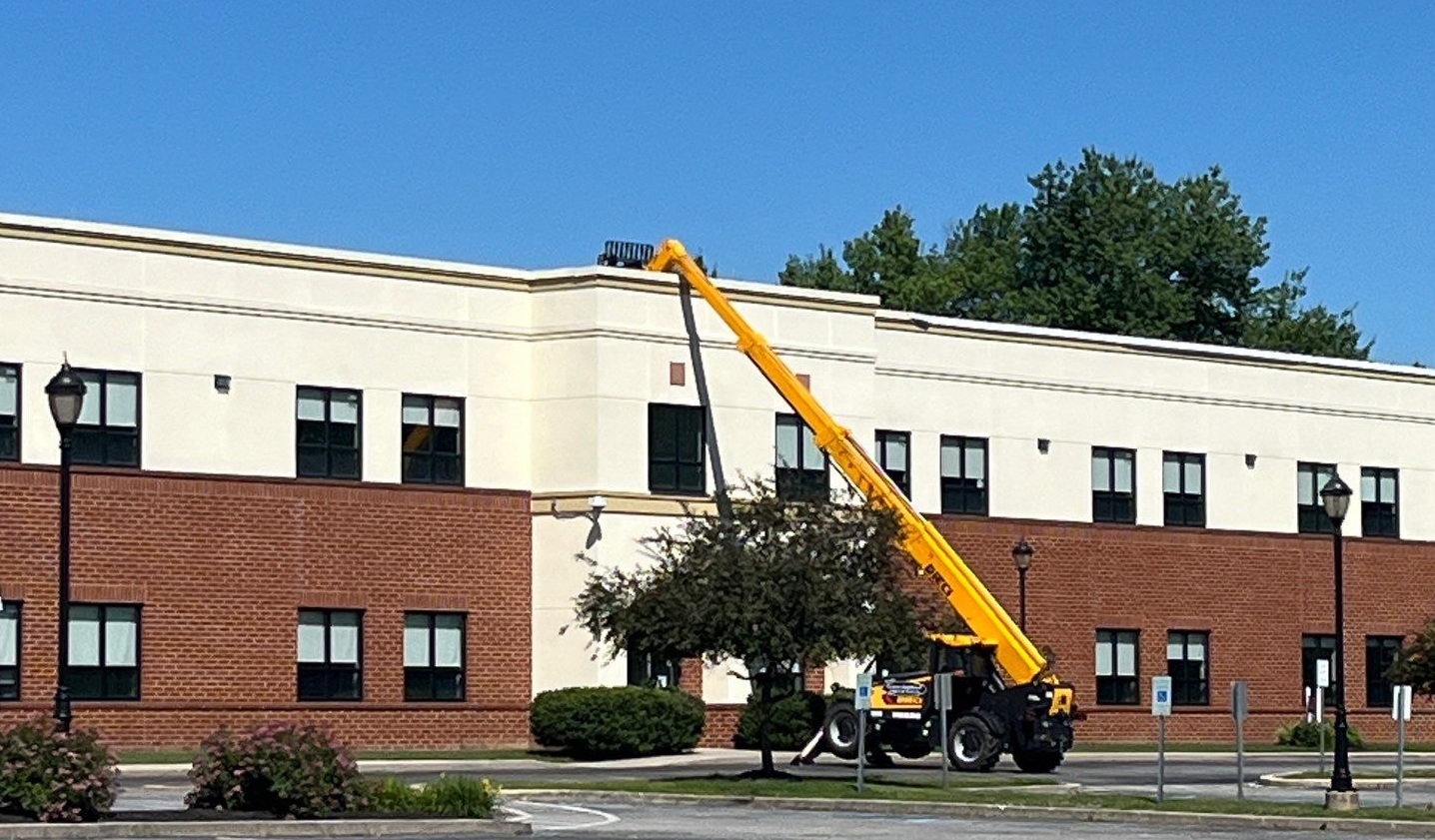 Crane going up to the roof of a building in a business park in Newark DE
