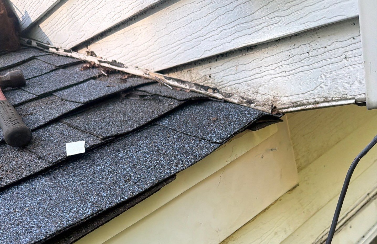 Closeup of lifted shingles caused by wind